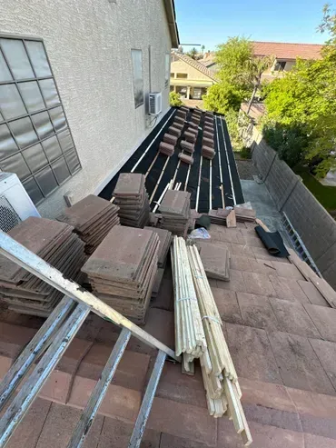 A roof with a lot of tiles on it is being repaired.