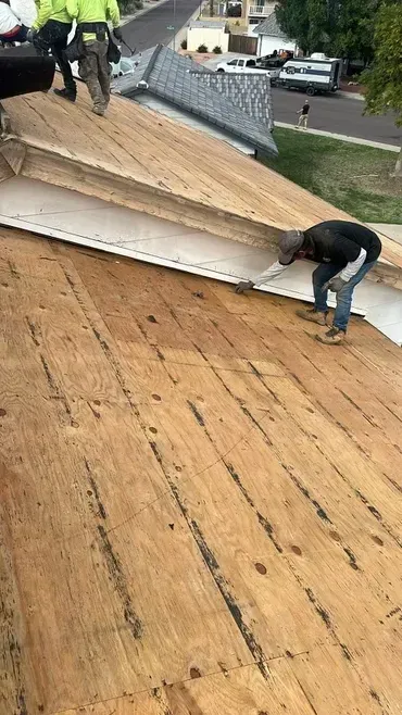A group of men are working on a wooden roof.