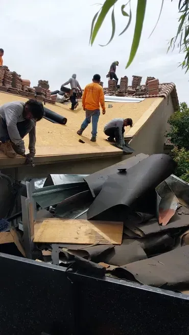 A group of men are working on the roof of a house