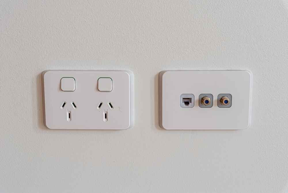 Two White Electrical Outlets And A Light Switch On A White Wall — Bastion Electrical In Wollongong, NSW