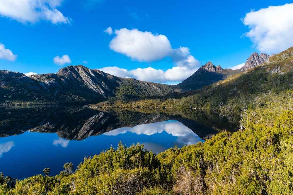 A Lake Surrounded By Mountains And Trees On A Sunny Day — Bastion Electrical In Fairy Meadow, NSW
