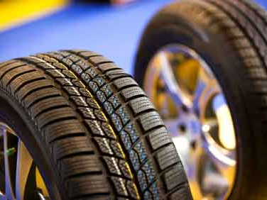Two car tires on silver rims, close up. The tires have a winter tread pattern.
