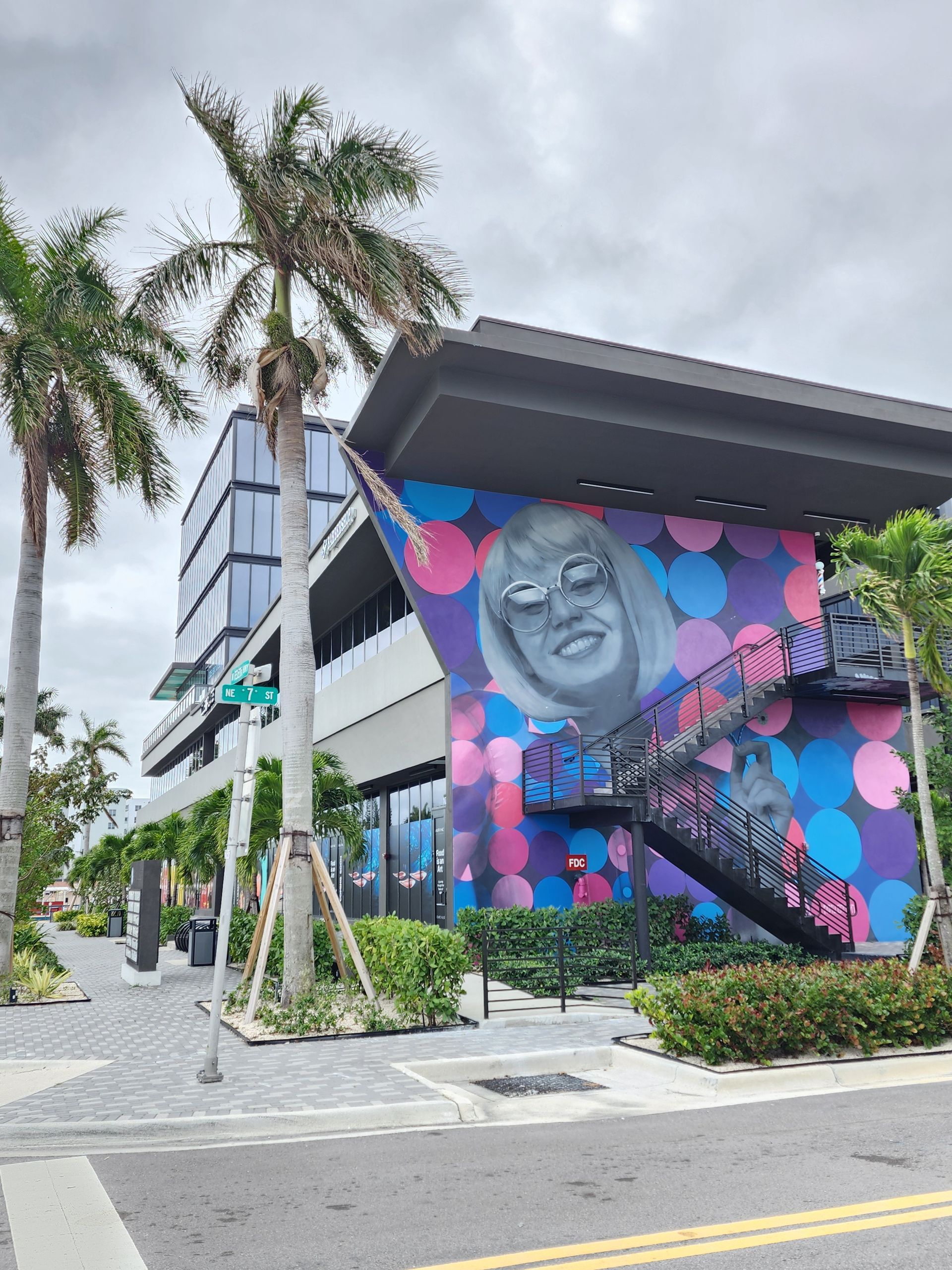 Un edificio con un mural de una mujer en el costado.
