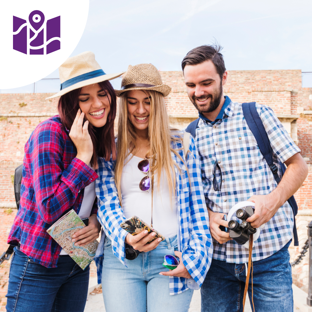Un grupo de personas están paradas una al lado de la otra mirando un teléfono celular.