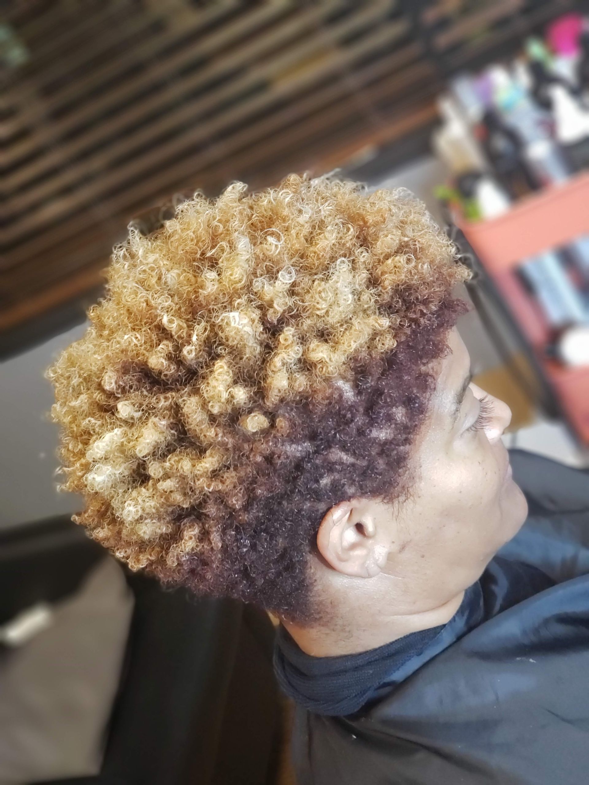 Two-story gray house with a three-car garage, wet driveway, and cloudy sunset.