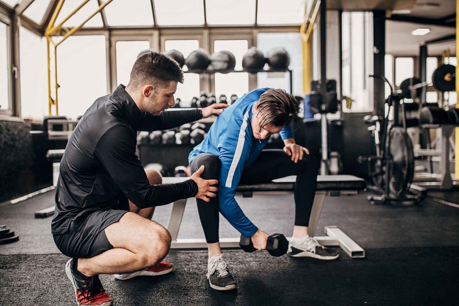 man working out assisted by personal trainer