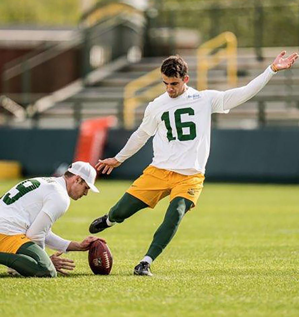 A football player in number 16 kicking a footbal