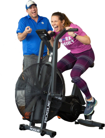 A man and a woman are standing next to an exercise bike.