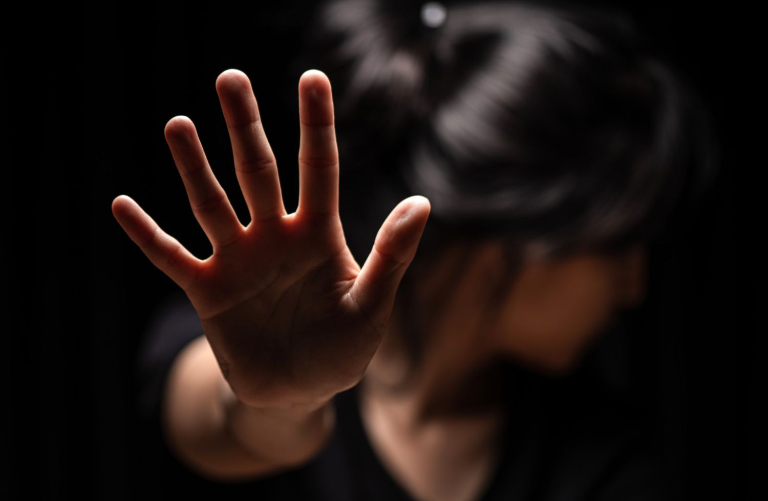 A woman is covering her face with her hand.