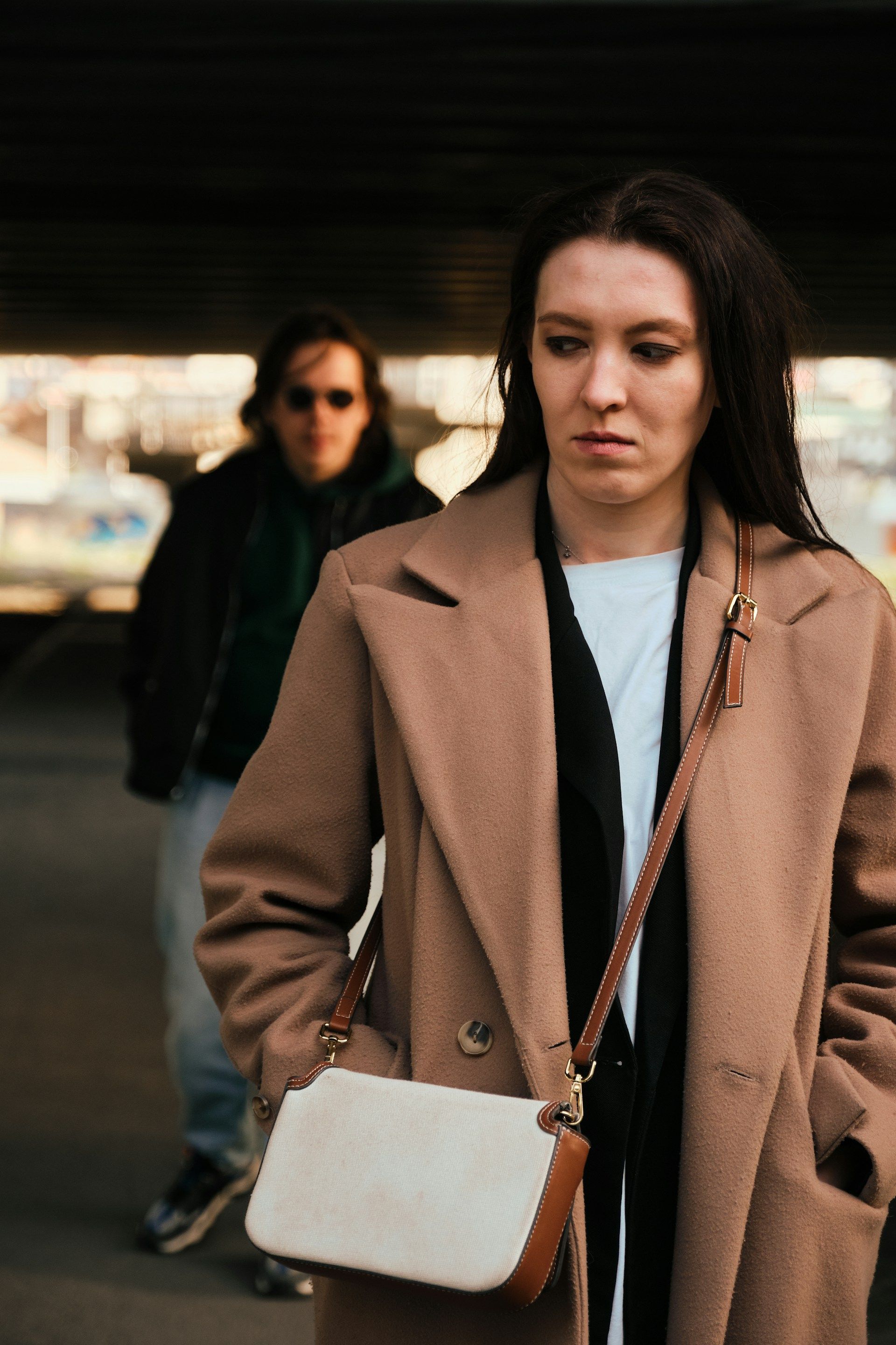 A woman in a brown coat is standing next to a man in a green jacket.