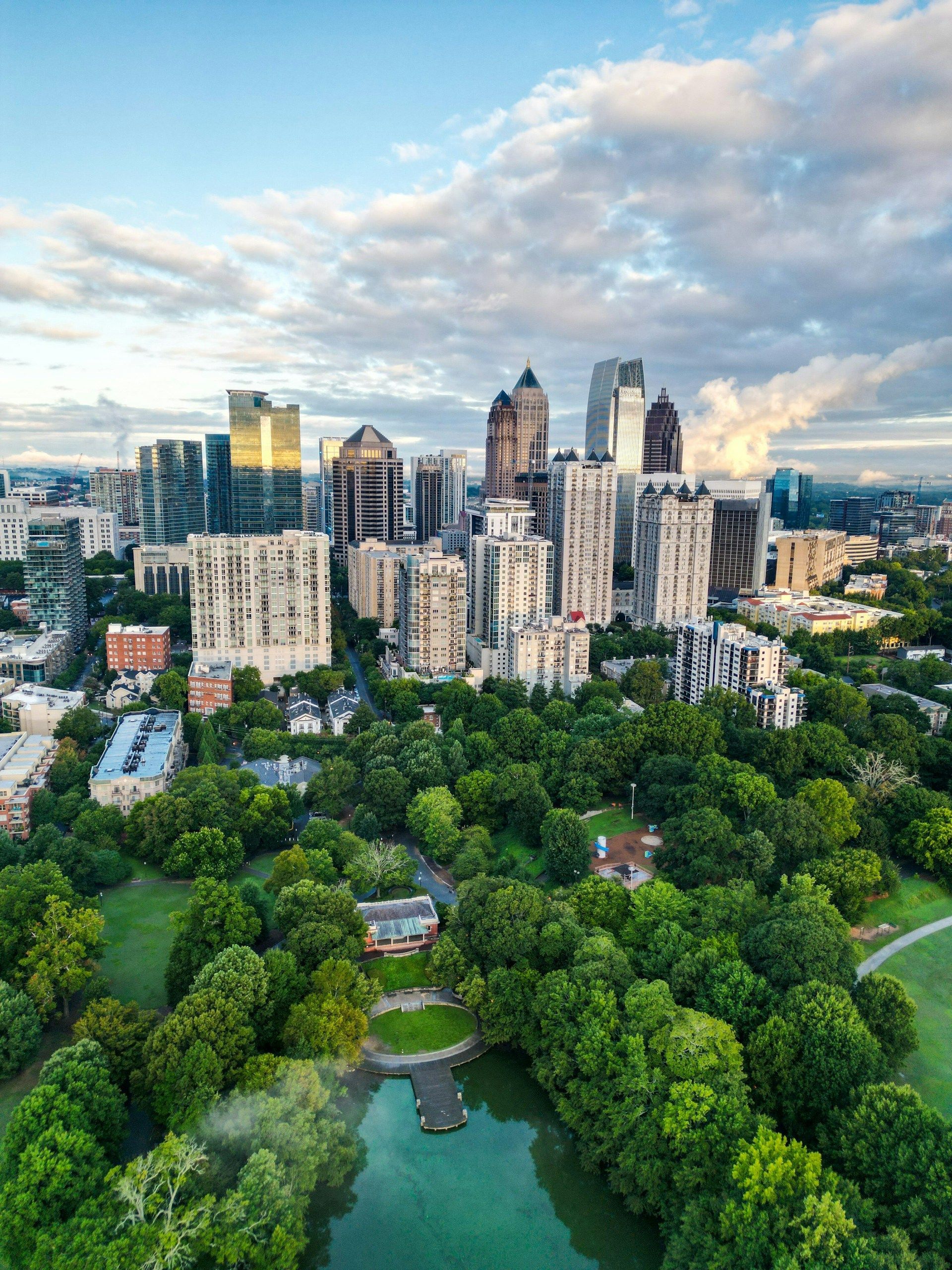 An aerial view of a park with a city skyline in the background.