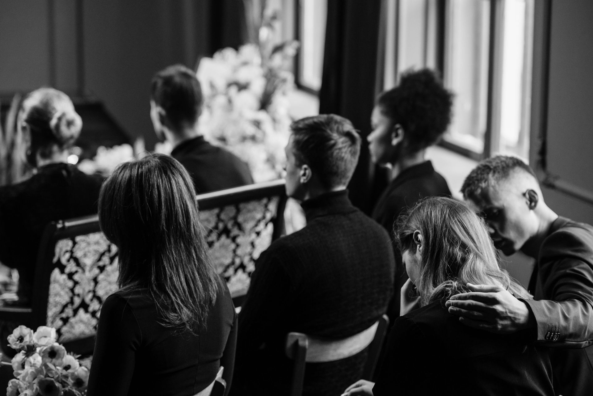 A group of people are sitting in a circle at a funeral.