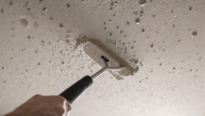 Hand scraping textured ceiling with a drywall knife under repair putty