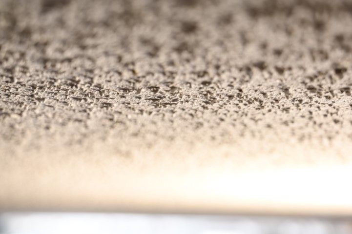 Close-up of a speckled, textured surface fading into a bright blurred area below