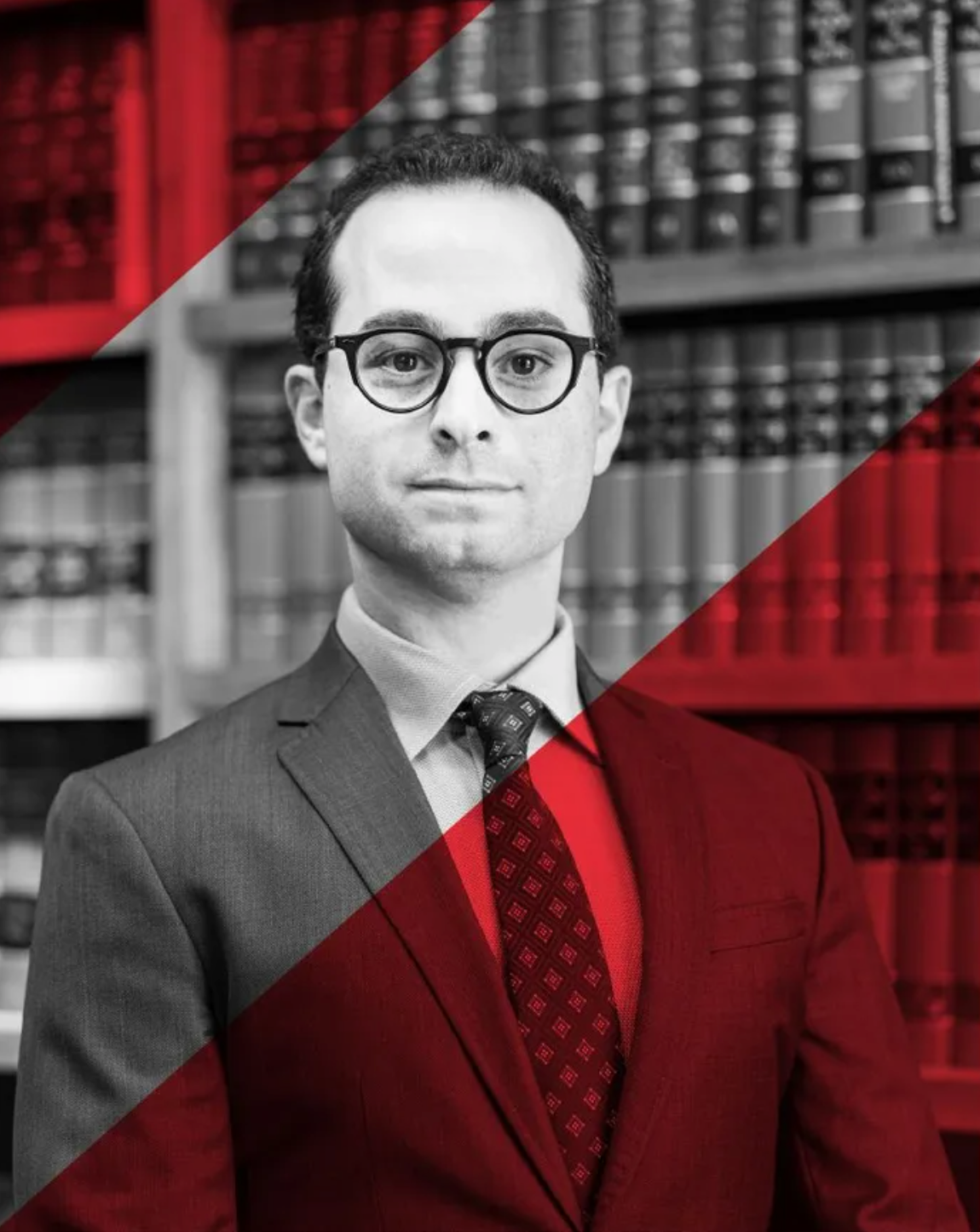 Man in suit and glasses in a library, red diagonal overlay.