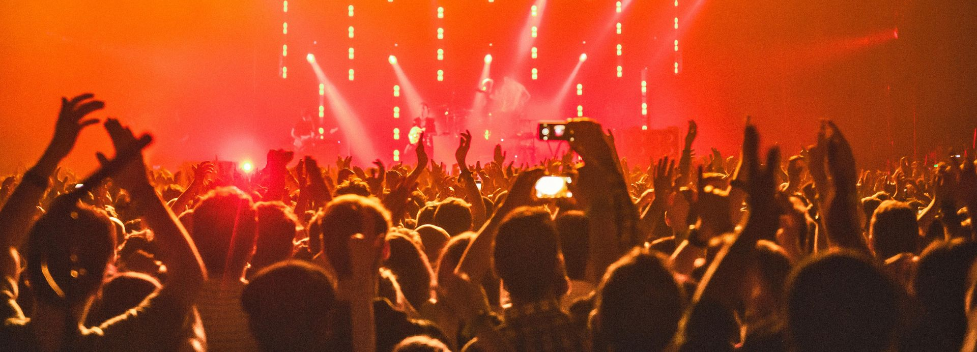 Large group of diverse people smiling, posing together in a room with natural light.
