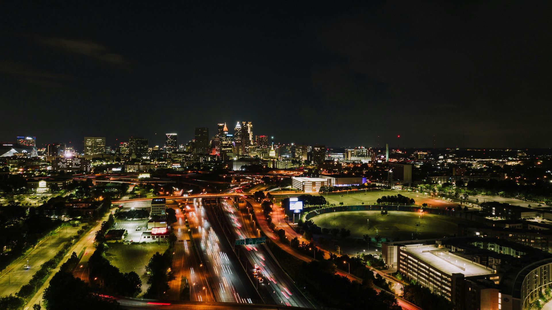 Nighttime aerial view of Columbus, Ohio, with highway traffic and city lights under a dark sky.