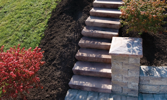 A set of stairs leading up to a brick wall