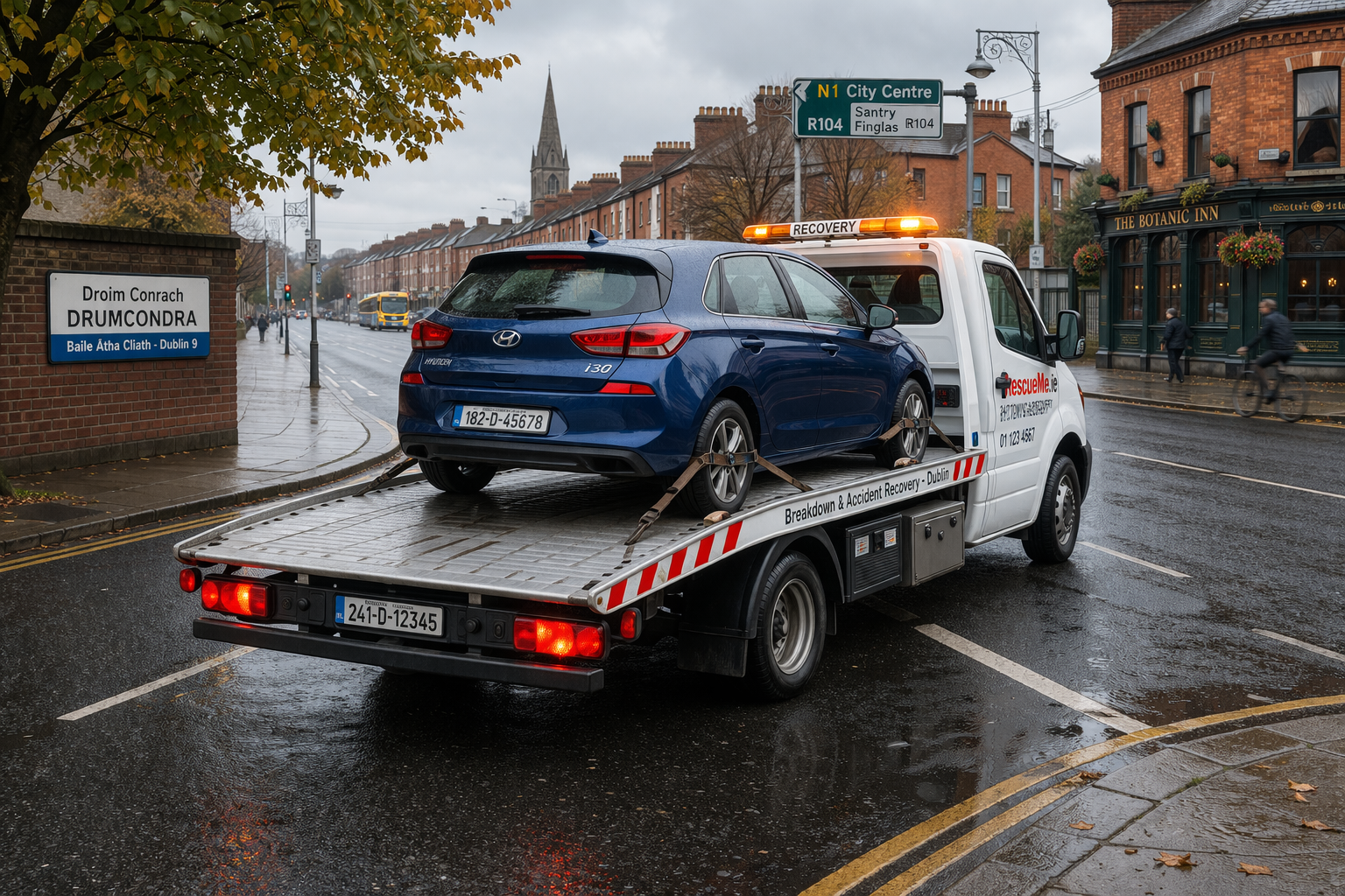white tow truck carrying blue car with Dublin registration in Drumcondra