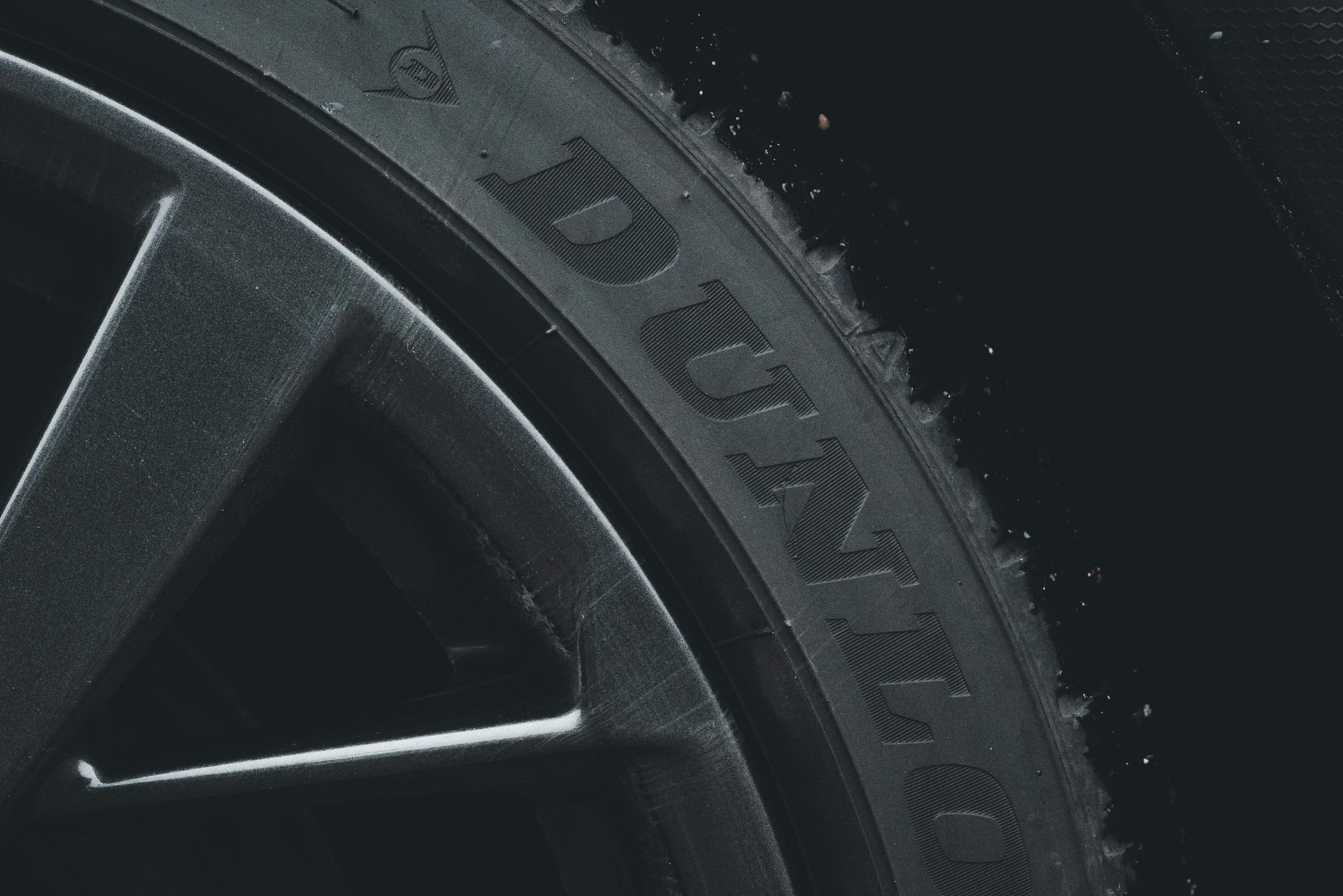Dunlop car  tyre with silver alloy wheel in black background