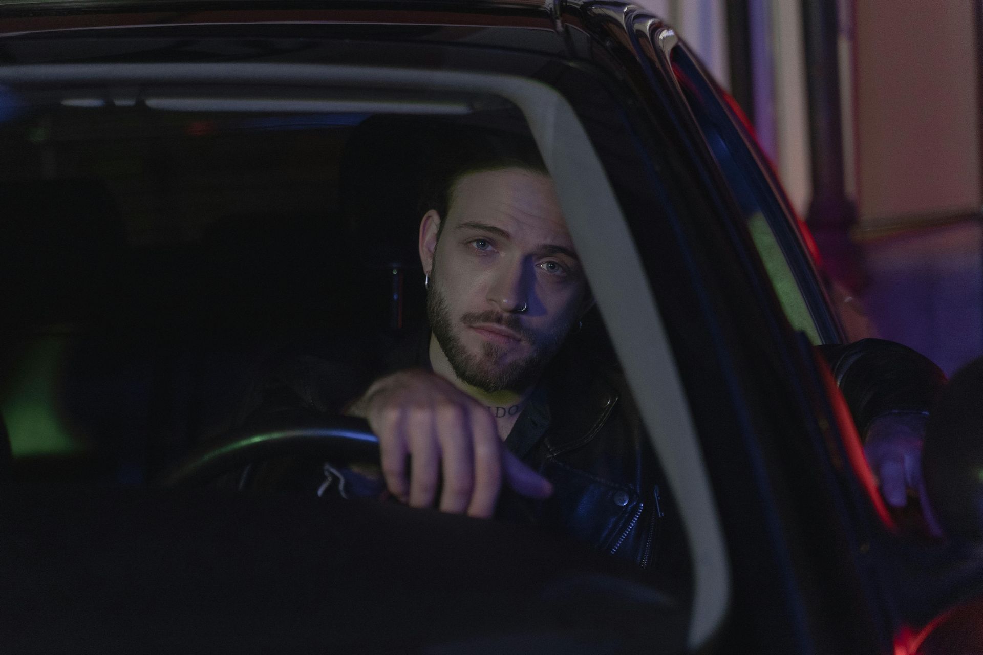 Male drver siting in a car at night