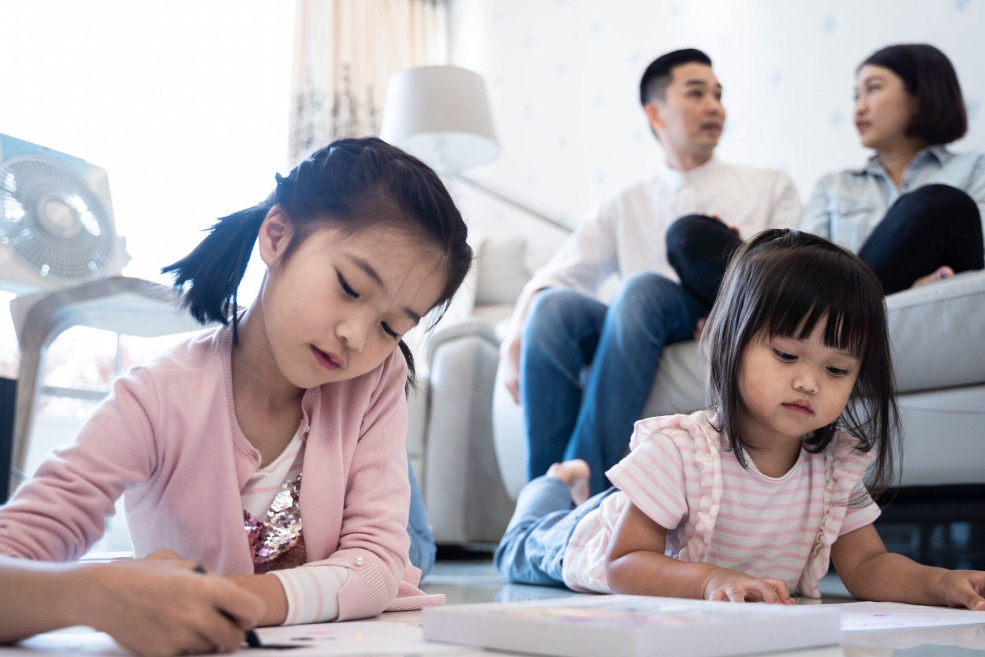 Two young children lying down on floor next to parents — Jacksonville, FL — Beaches Family Law