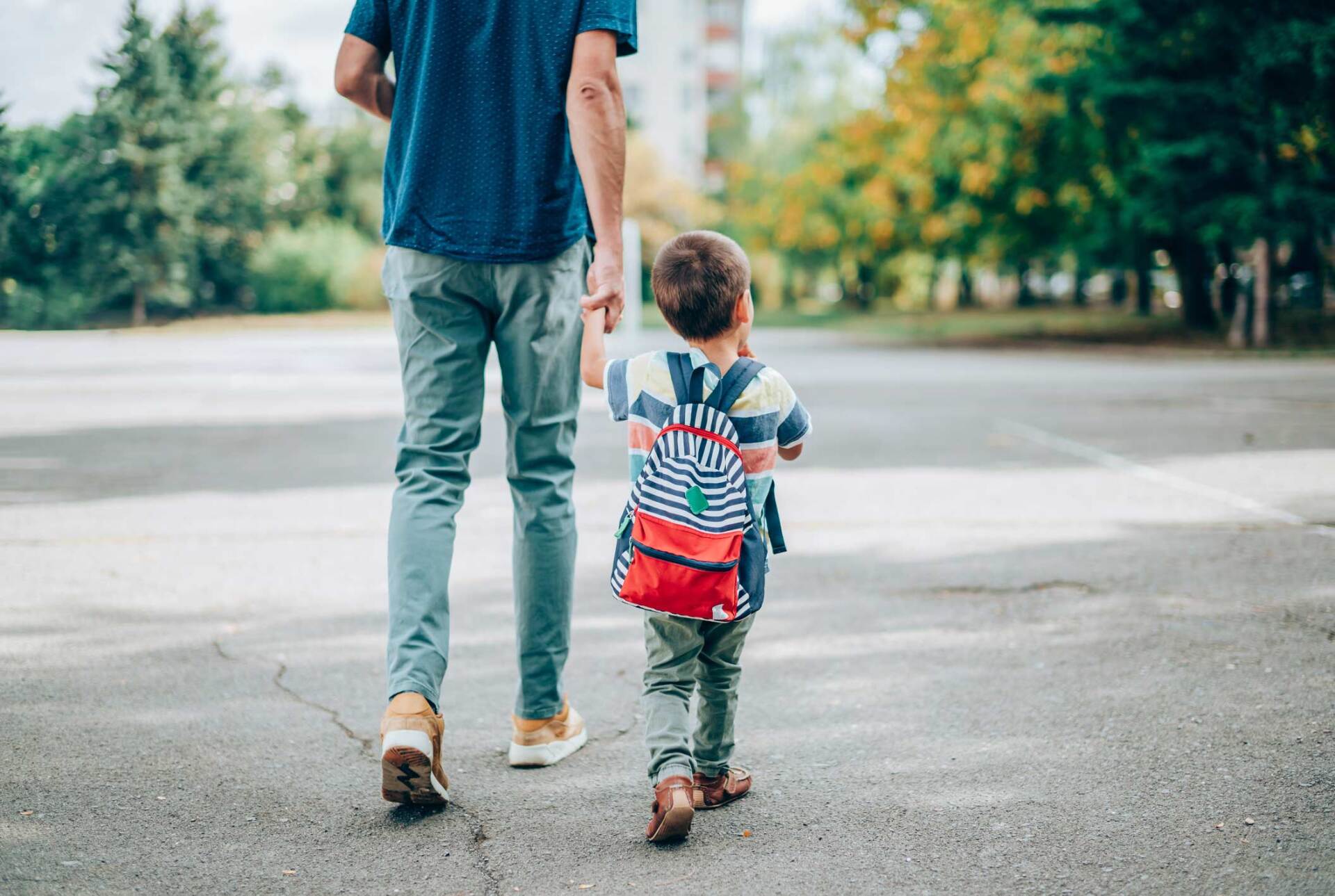 Father walking son with backpack — Jacksonville, FL — Beaches Family Law