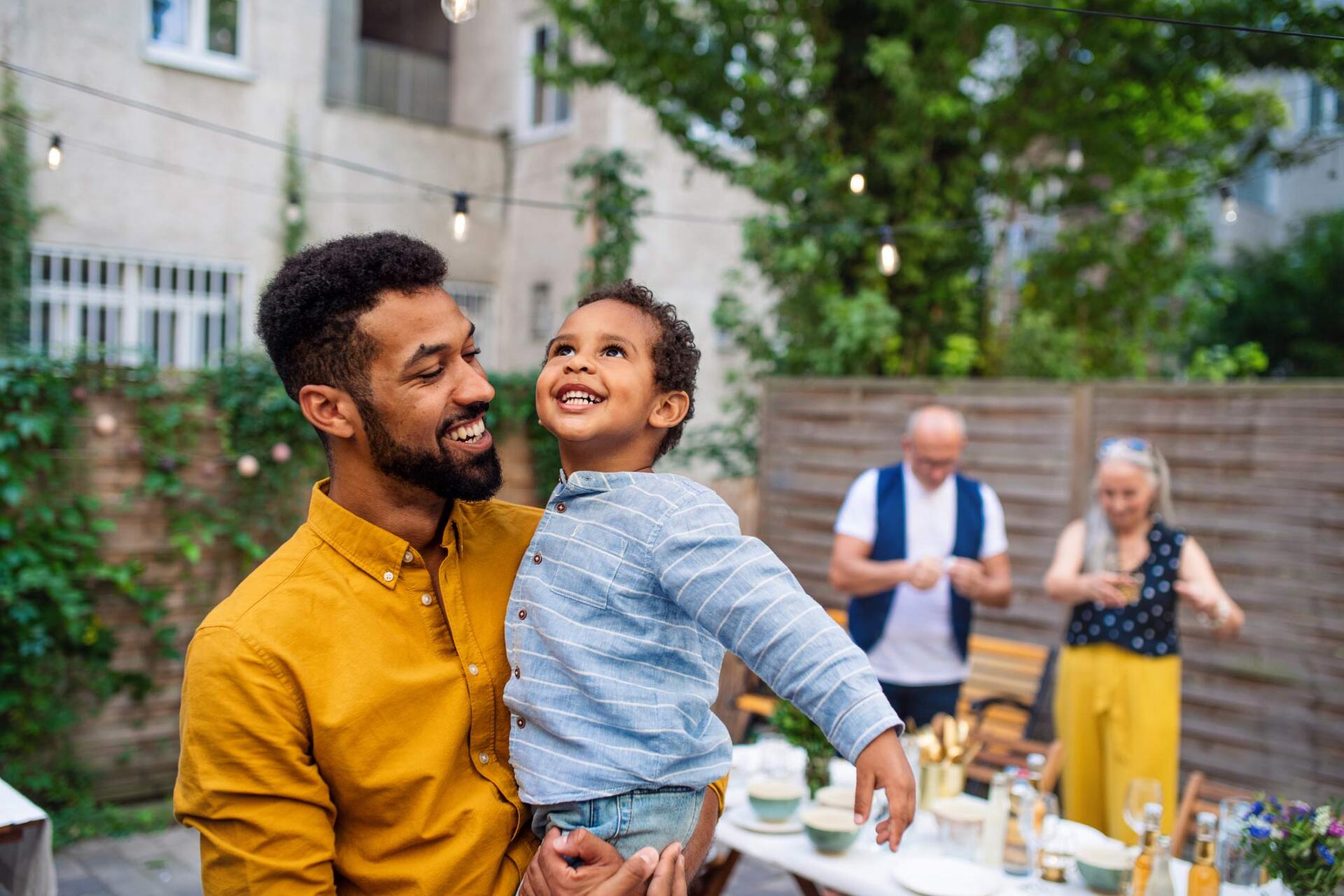 Father holding child with grandparents behind — Jacksonville, FL — Beaches Family Law