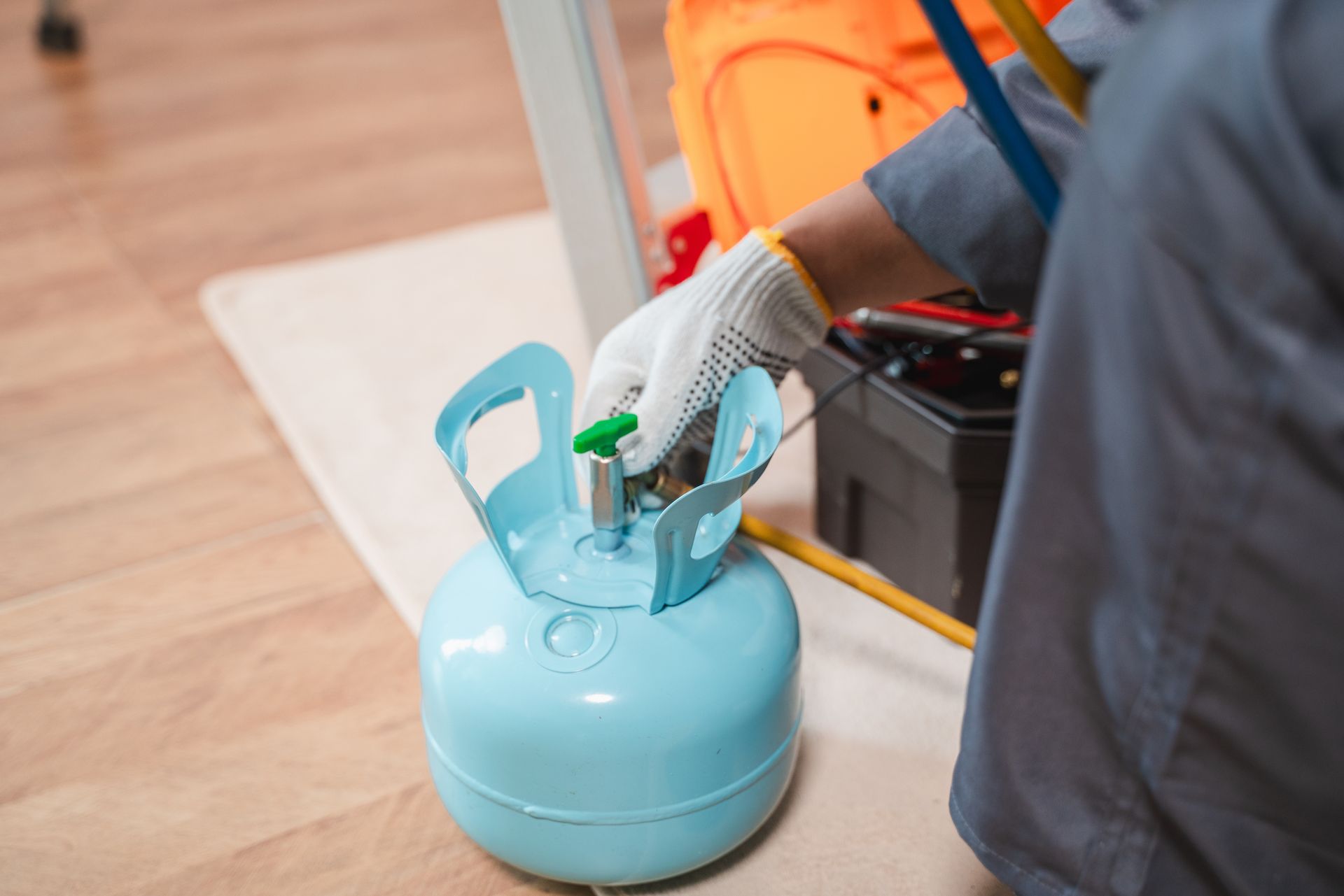Gas technician with blue cylinder, representing professional residential propane delivery.