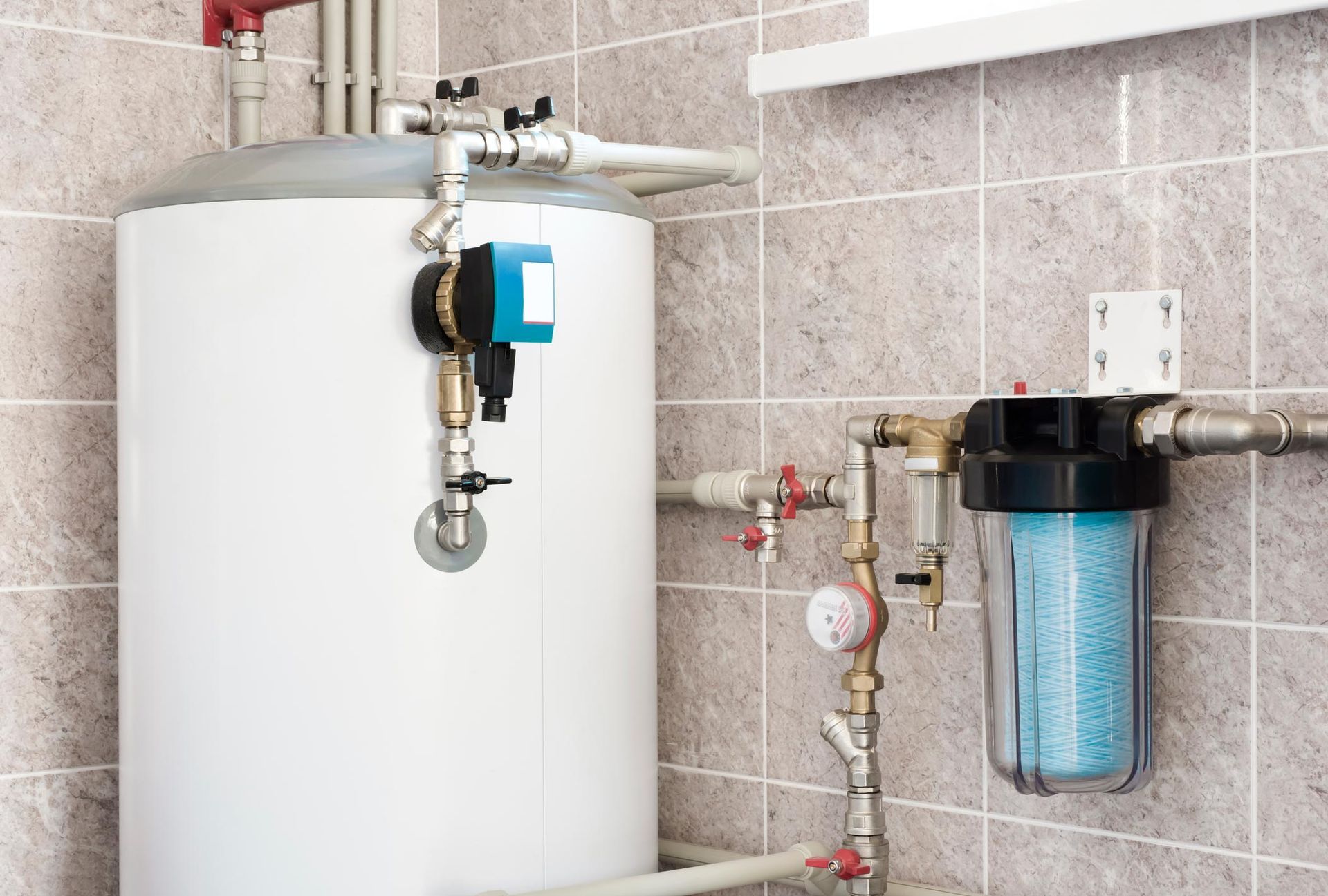 White water heater with pipes and a water filter in a tiled room.