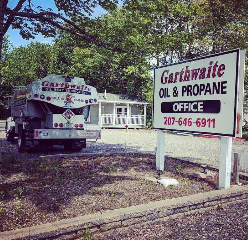 Fuel tanker truck on a highway under a cloudy sky, displaying a flammable hazard sign.