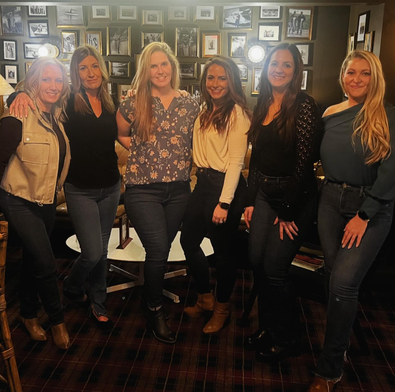 Person using a wrench on a water heater, with blue pipes and expansion tank visible.