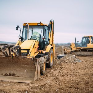 Yellow backhoe and bulldozer on a construction site.