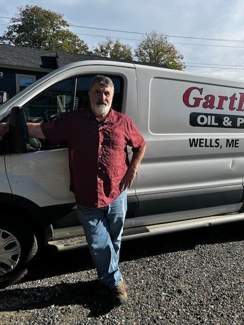 Man opening a white boiler in a blue room.