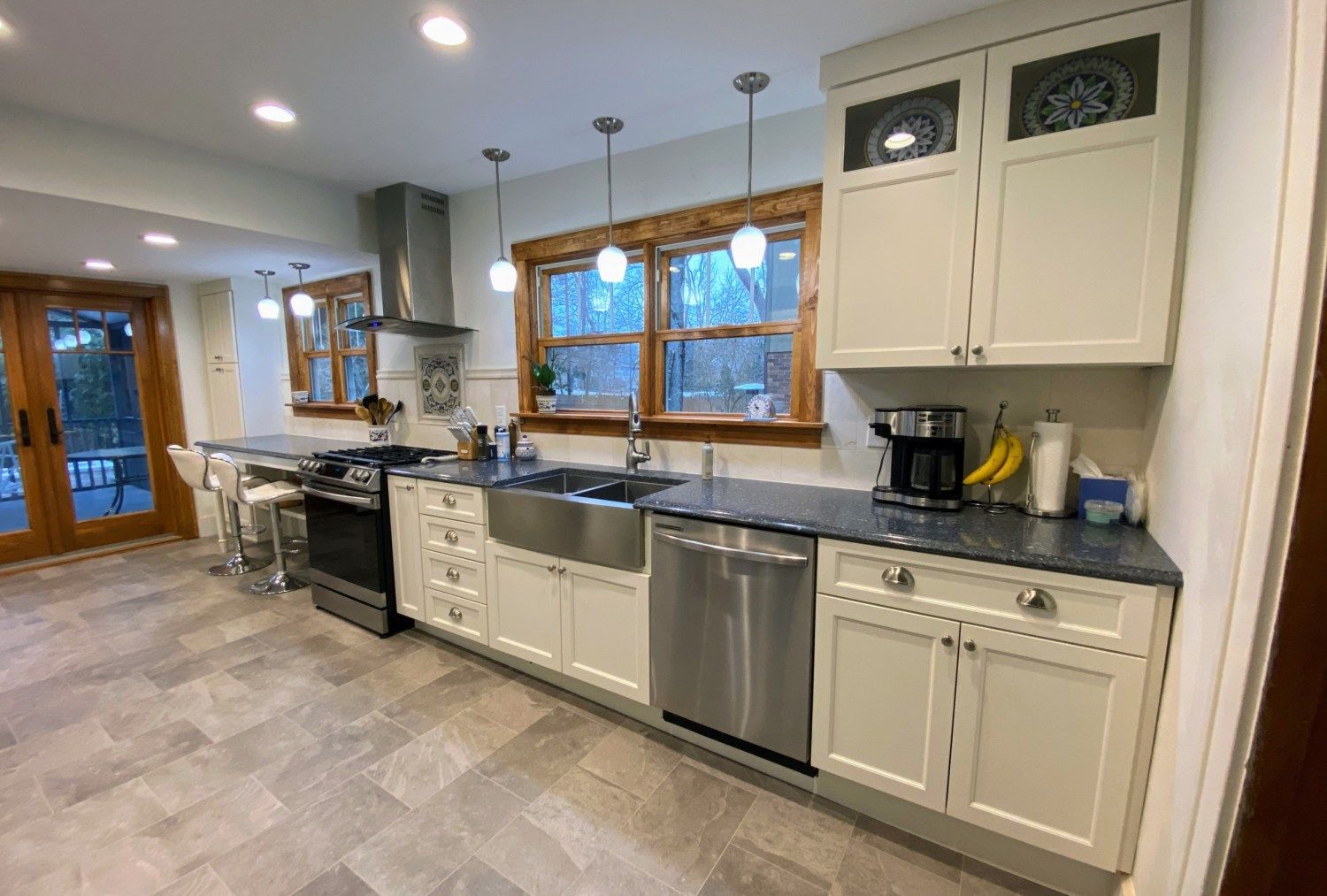 A kitchen with white cabinets , stainless steel appliances , a sink , and a stove.