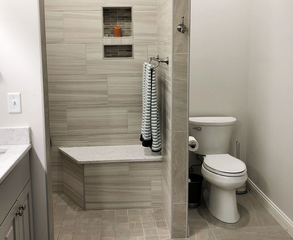 A bathroom with a toilet , sink and shower.