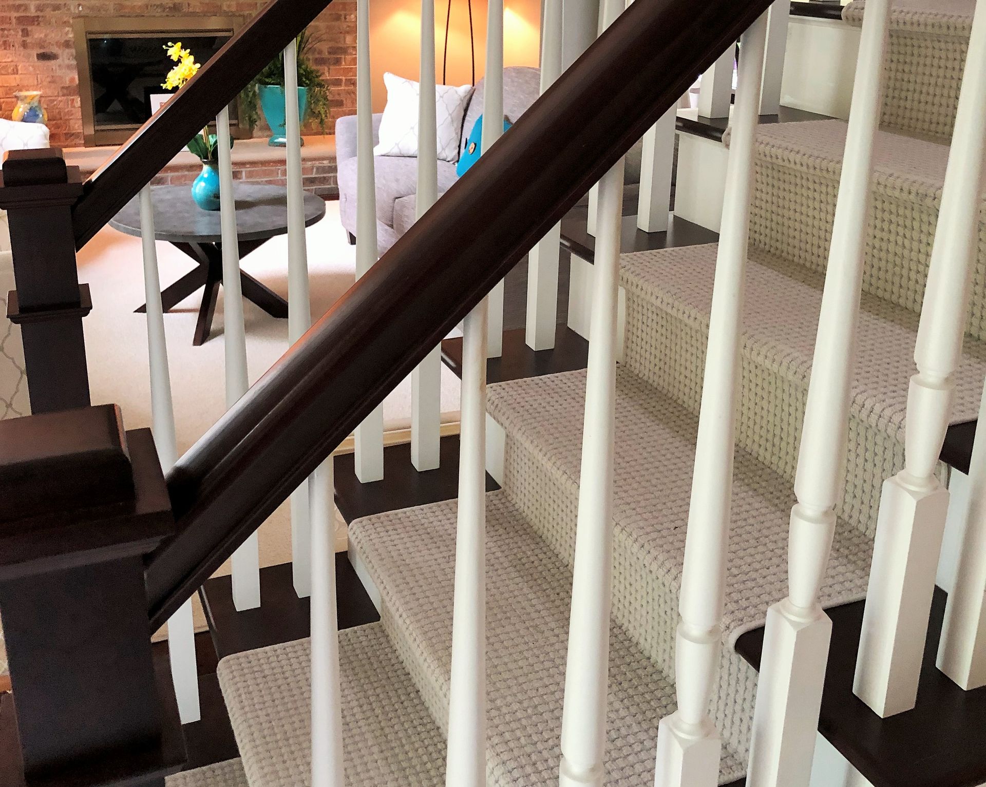 A staircase with a white railing leading up to a living room