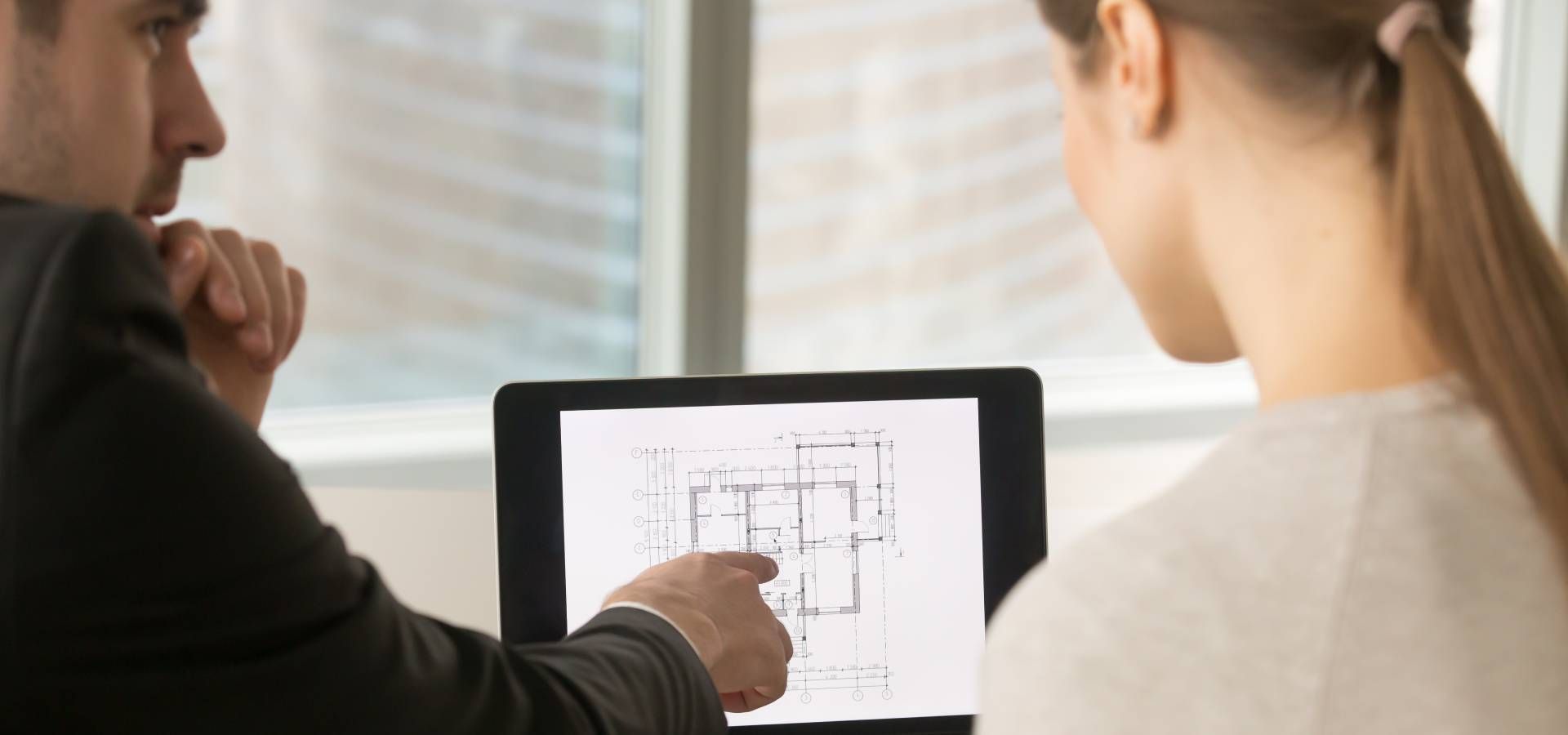 A man and a woman are looking at a tablet computer.