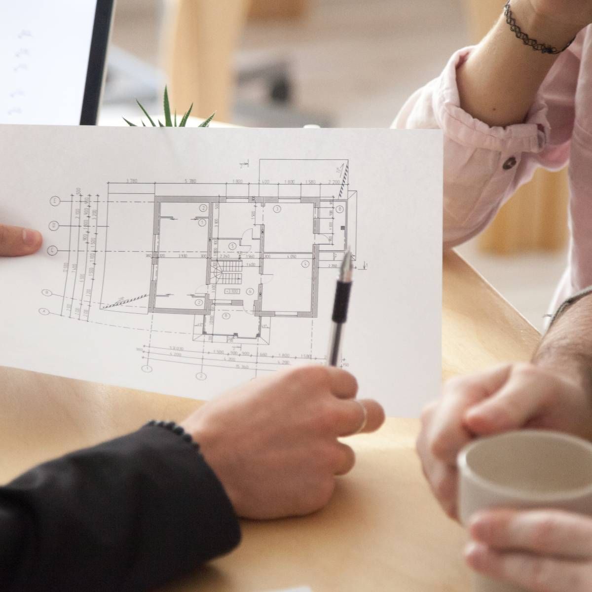 Two people are looking at a floor plan of a house