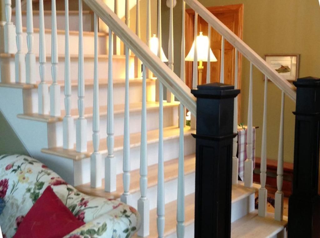 A staircase with white railings and black pillars