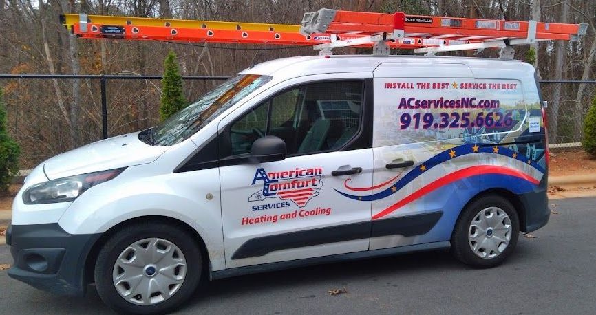 A white van with a ladder on top of it is parked on the side of the road.