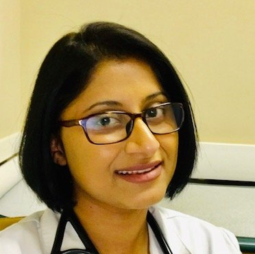 A woman wearing glasses and a stethoscope around her neck