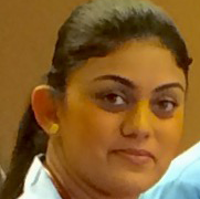 A close up of a woman 's face with a ponytail and earrings.
