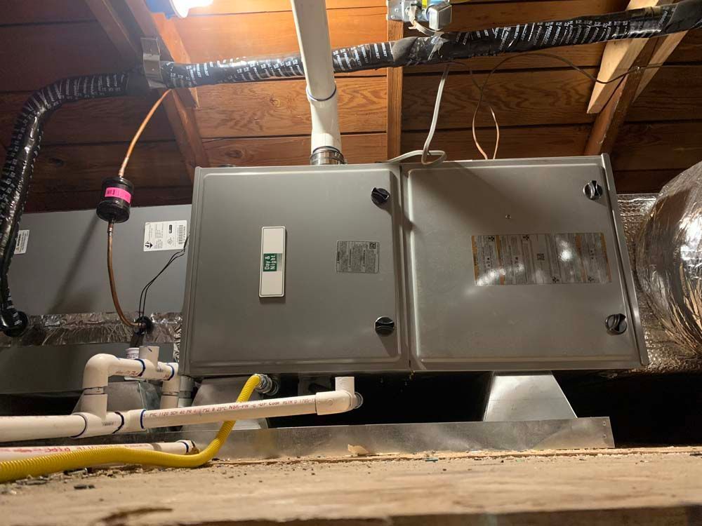 Basement with furnace, water heater, ductwork, and partially visible room with open door.