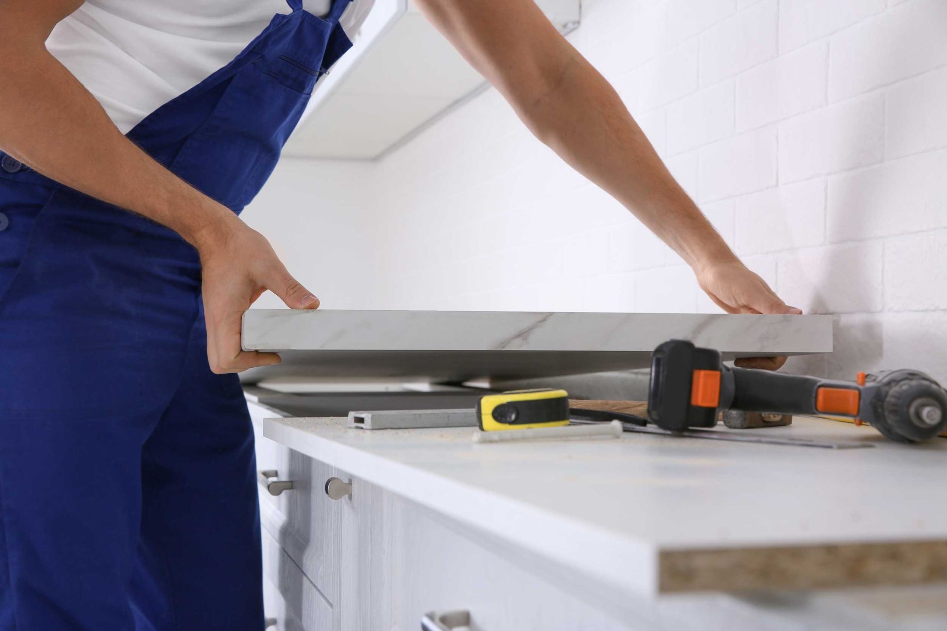 A man is installing a kitchen countertop. A man is installing a kitchen countertop.