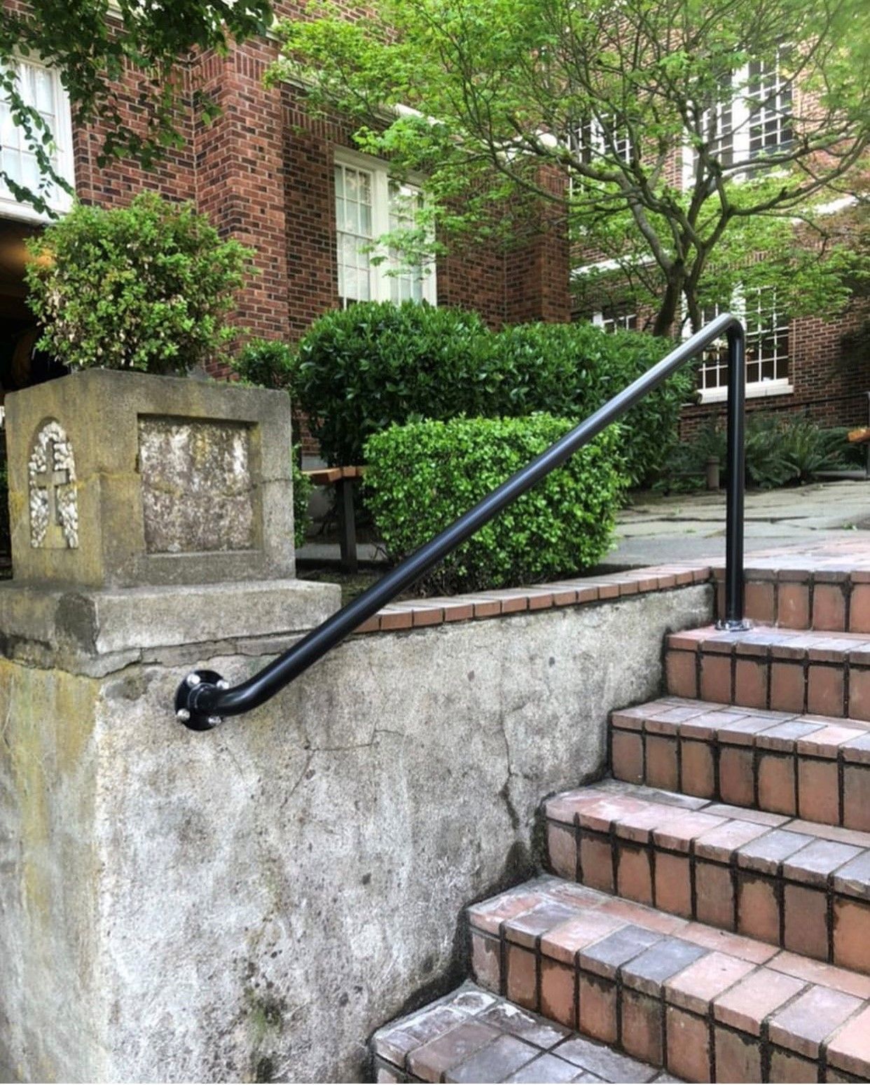 Brick steps lead up to a building with a handrail.