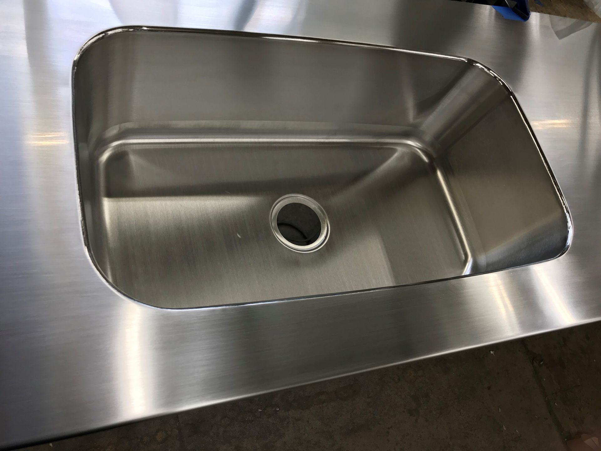 Stainless steel kitchen sink in a brushed metal countertop.