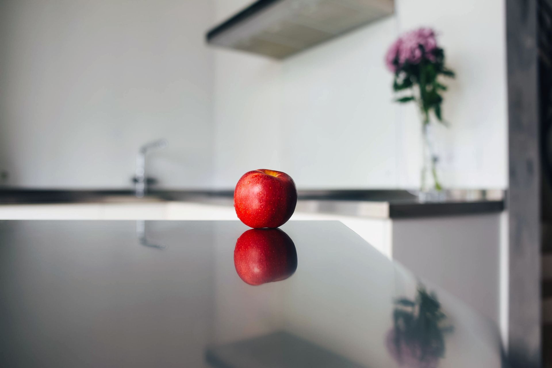 The apple lies on the table against the background of a modern kitchen. The apple lies on the table against the background of a modern kitchen.