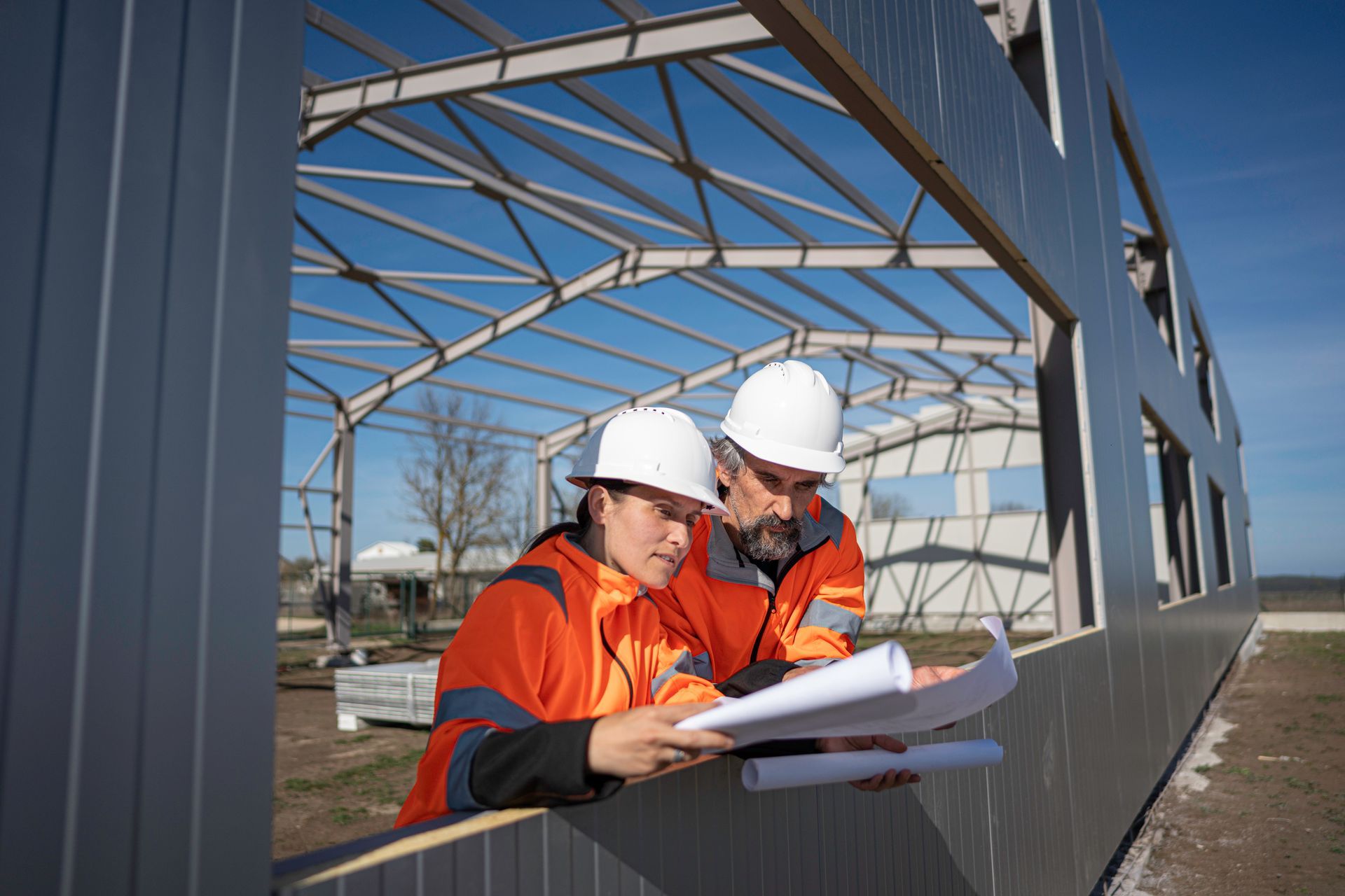 Civil engineer and architect inspecting metal building framing.