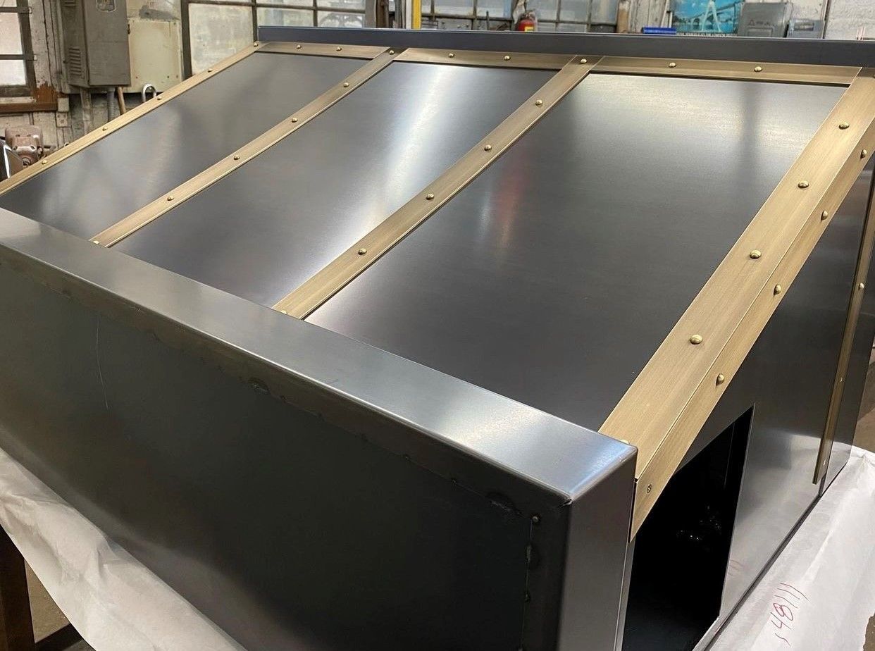 Angled metal box with brass accents.